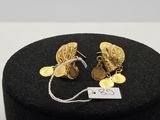 un gros plan sur une paire de boucles d'oreilles posées sur une boîte noire