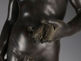 bronze statue of a man holding a leaf in his right hand