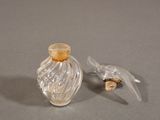 a small glass bottle with a bird on top of it