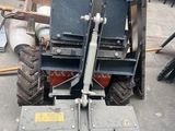 a forklift that is sitting on the ground next to a pile of junk