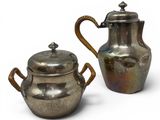 pair of silver plated teapots with handles and a lid