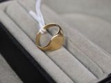 une bague en or posée dans une boîte, attachée à un cordon blanc