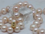 pearls are arranged on a white surface with a crystal cube