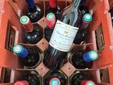 many bottles of wine in a red crate on the floor