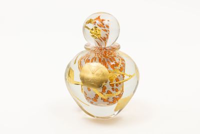 un flacon de parfum en verre orné d'un motif doré