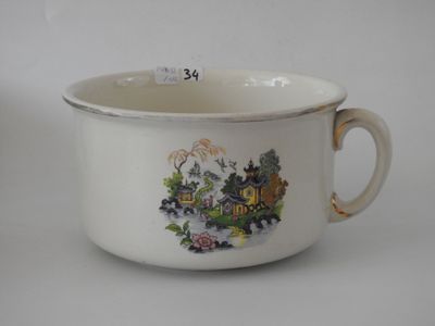 a white cup with a picture of a house on it