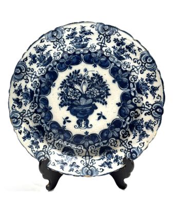 an image of a blue and white plate with a flower arrangement on it