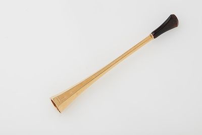 a wooden stick with a black handle sitting on a white surface