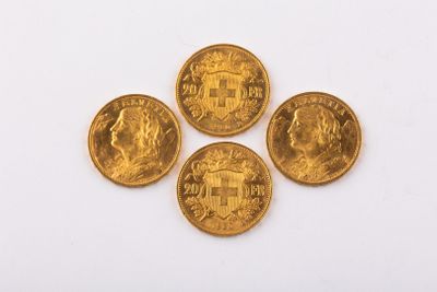 four gold coins are arranged on a white surface