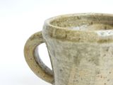 a close up of a coffee cup on a white surface