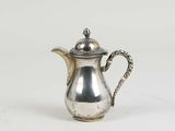 a silver tea pot with a handle on a white surface