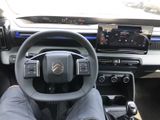 someone is sitting in the driver ' s seat of a car with their feet on the steering wheel