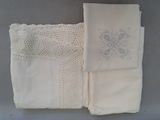 deux morceaux de tissu blanc ornés de dentelle, posés sur une table