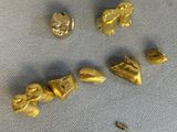quatre pièces d'or sont disposées sur un tissu bleu