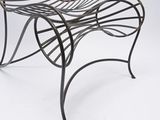 an iron chair with a curved back and a curved seat