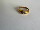 une bague en or sertie de pierres bleues sur un fond blanc