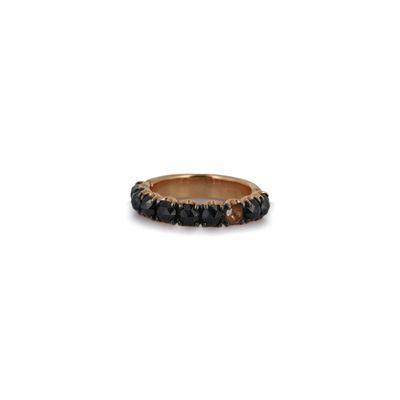 une bague en or ornée de pierres noires sur fond blanc