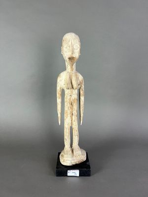 une statue blanche représentant un homme debout sur un socle noir