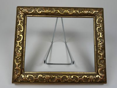 gold frame with a triangle in it on a white surface