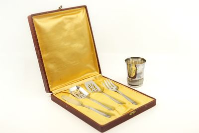 silverware in a wooden case with a cup and spoons