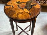 a small table with a painting on it in a living room