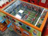 une table sur laquelle se déroule un match de foot, dans un magasin