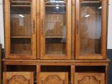 an image of a wooden cabinet with glass doors and a painting on the wall