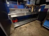 un évier en inox dans une cuisine carrelée de bleu et de blanc