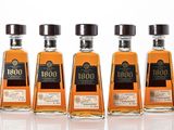 trois bouteilles de bourbon sont alignées sur une surface blanche