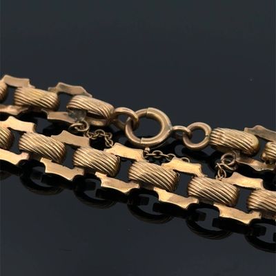 un gros plan d'un bracelet plaqué or sur un fond noir