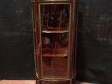une petite armoire d'angle dotée d'une porte vitrée