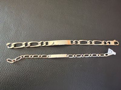 une paire de bracelets en or posés sur un fond en cuir noir