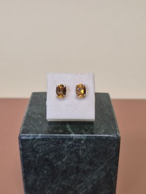 un gros plan sur une paire de boucles d'oreilles posées sur un bloc de marbre