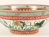 a colorful bowl with birds on it on a white surface