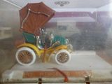une petite voiture avec un landau, exposée dans une vitrine