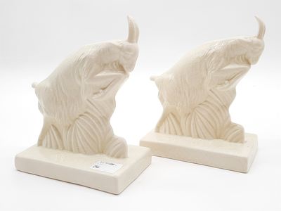 pair of white ceramic sculptures of a bull and a bull ' s head