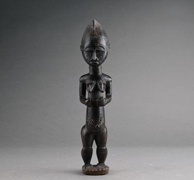 une vieille statue en bois d'un homme avec un chapeau sur la tête