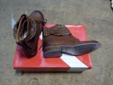 a pair of brown shoes on a box on the floor