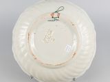 underside view of a white plate with a bow on the edge