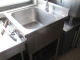 a stainless steel sink in the corner of a kitchen