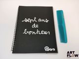a notebook with writing on it and a comb next to it