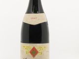 une vieille bouteille de vin posée sur une surface blanche