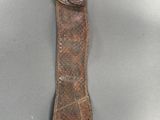 a close up of a knife with a leather sheath on a table