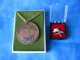 une petite boîte contenant un collier et une pièce de monnaie