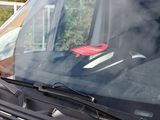 a red sticker on the windshield of a car