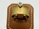 an image of a gold ring with a diamond on top of a brown leather box