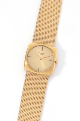 a close up of a gold watch on a white surface
