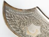 a silver plate with a decorative design on it