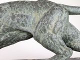 a statue of a dog that is running on a table