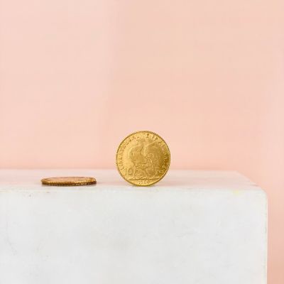 a gold coin sitting on top of a white box